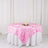 Pink rose-patterned tablecloth on a round dining table with white draping.