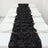 Black rose table runner with white plates set on a dining table.