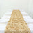 Gold rose table runner on a white table with empty plates.