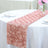 Pink rose-patterned table runner on a white tablecloth.