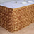 Gold rose-patterned tablecloth draping over a table with a white top.