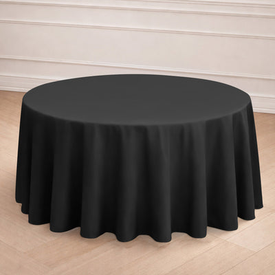 Round black tablecloth on a wooden floor backdrop.
