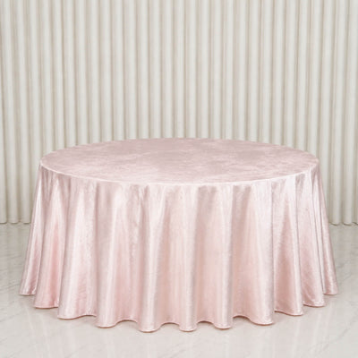 Round blush pink satin tablecloth on a banquet table against draped backdrop