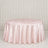 Round blush pink satin tablecloth on a banquet table against draped backdrop