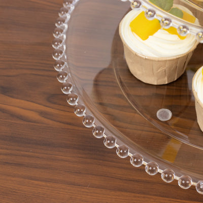 Clear acrylic cake stand displaying cupcakes with colorful toppings.