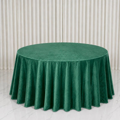Round green velvet tablecloth on a banquet table with elegant draped backdrop