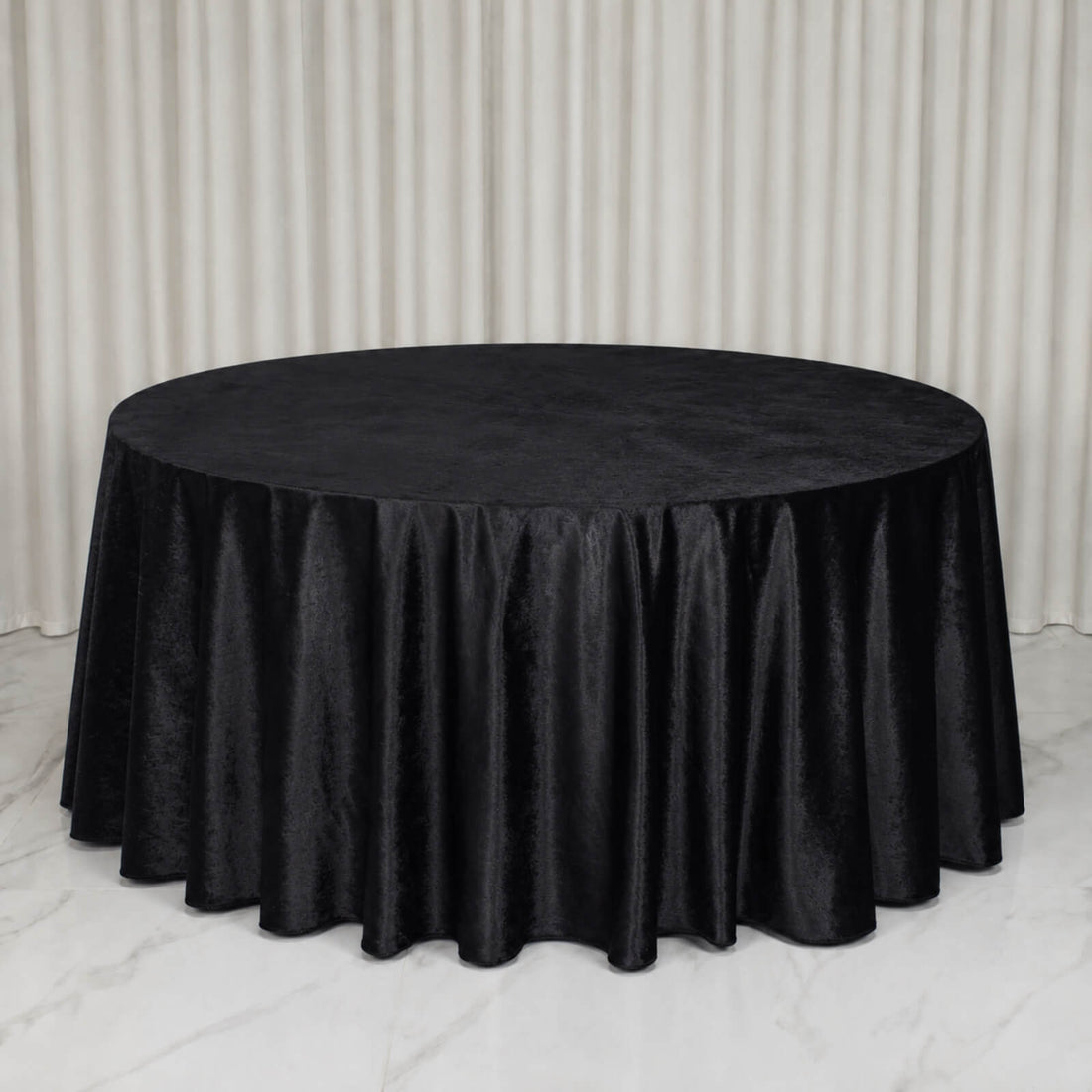 Round table with black velvet tablecloth in elegant event setting