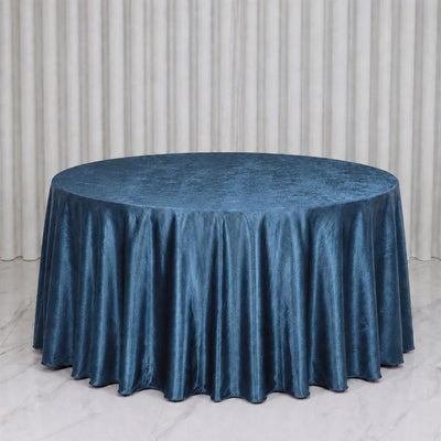 Round table with blue satin tablecloth against white curtains