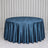Round table with blue satin tablecloth against white curtains