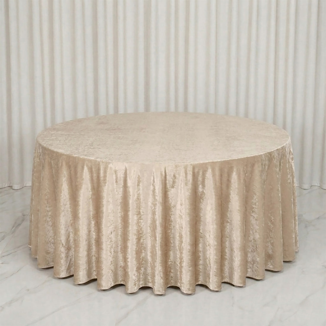 Round table with champagne velvet tablecloth in elegant event setup