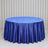 Round table with royal blue satin tablecloth against white curtains