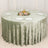 Round table with sage velvet tablecloth, floral centerpiece, and gold decor