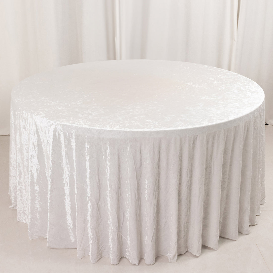 Round table with white velvet tablecloth in elegant minimalist setting