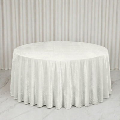 Round white tablecloth on a banquet table in a minimal white room