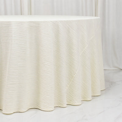 Round white textured event table with pleated draped linen cover