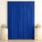 Royal blue curtain backdrop with white floral arrangements and candles