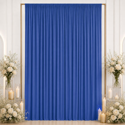 Royal blue event curtain with white floral arrangements and candles