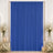 Royal blue event curtain with white floral arrangements and candles