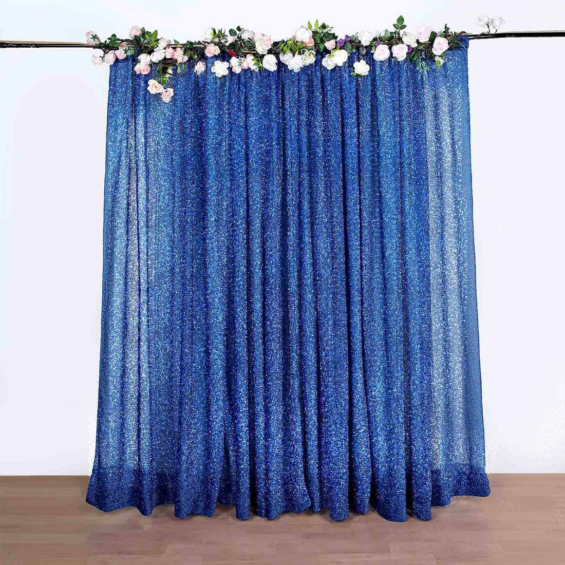 Blue glitter curtain with floral accents, ideal for events and decorations.