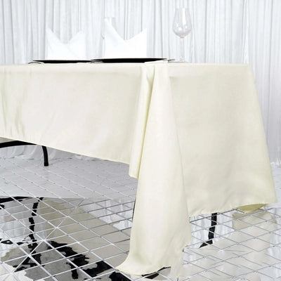 Elegant cream tablecloth draping over a sleek table with glassware.