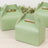 Green gable boxes on a wooden surface, perfect for gifts or takeout.