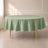 Sage green round tablecloth on a dining table with golden legs.