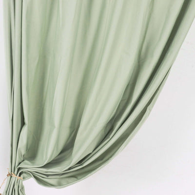 Soft green fabric draped elegantly, showcasing its flow and texture.