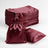 Burgundy satin drawstring bags stacked with one bag and pillow on a white background