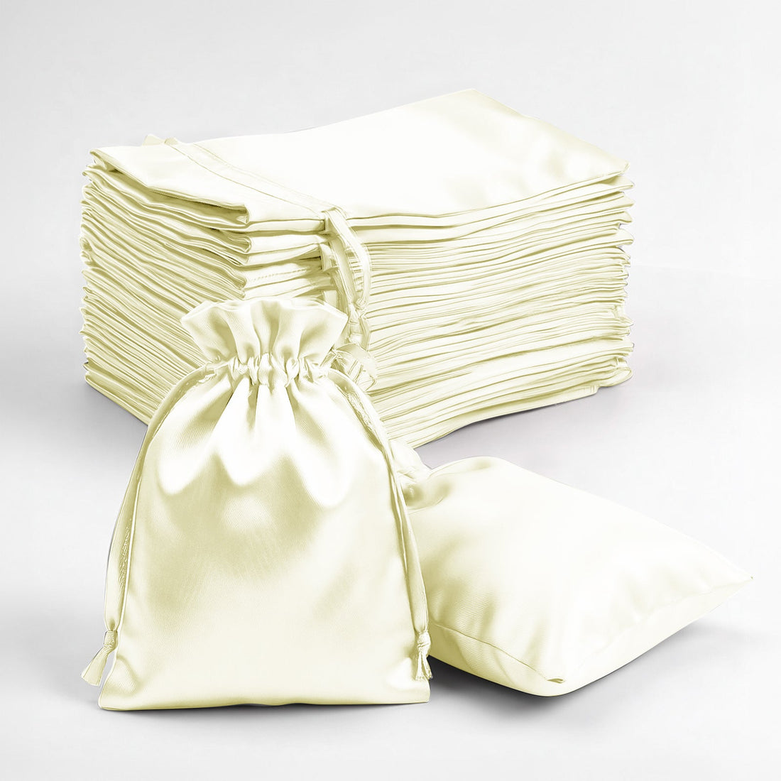 Stack of satin bags in cream color on a white background.