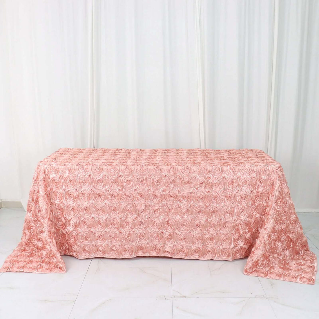 Pink rose-patterned tablecloth on a white background.