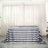 Black and white striped tablecloth on a table with sheer curtains in the background.
