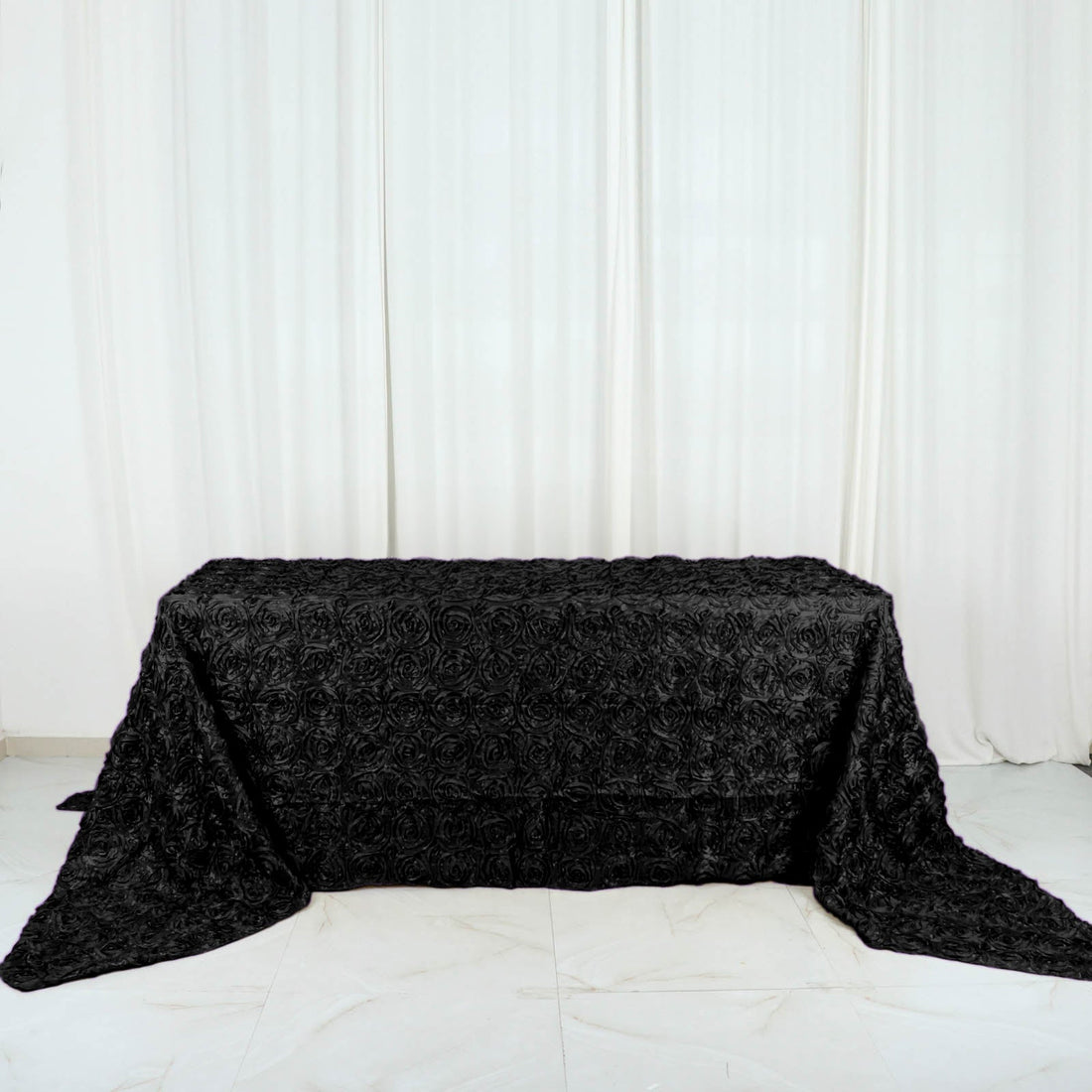 Black rose-patterned tablecloth on a plain surface.