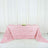 Pink rose-patterned tablecloth draped over a table in a bright setting.