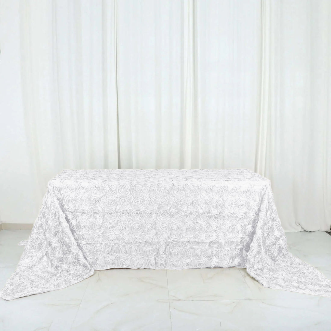 White rose-patterned tablecloth on a plain backdrop.