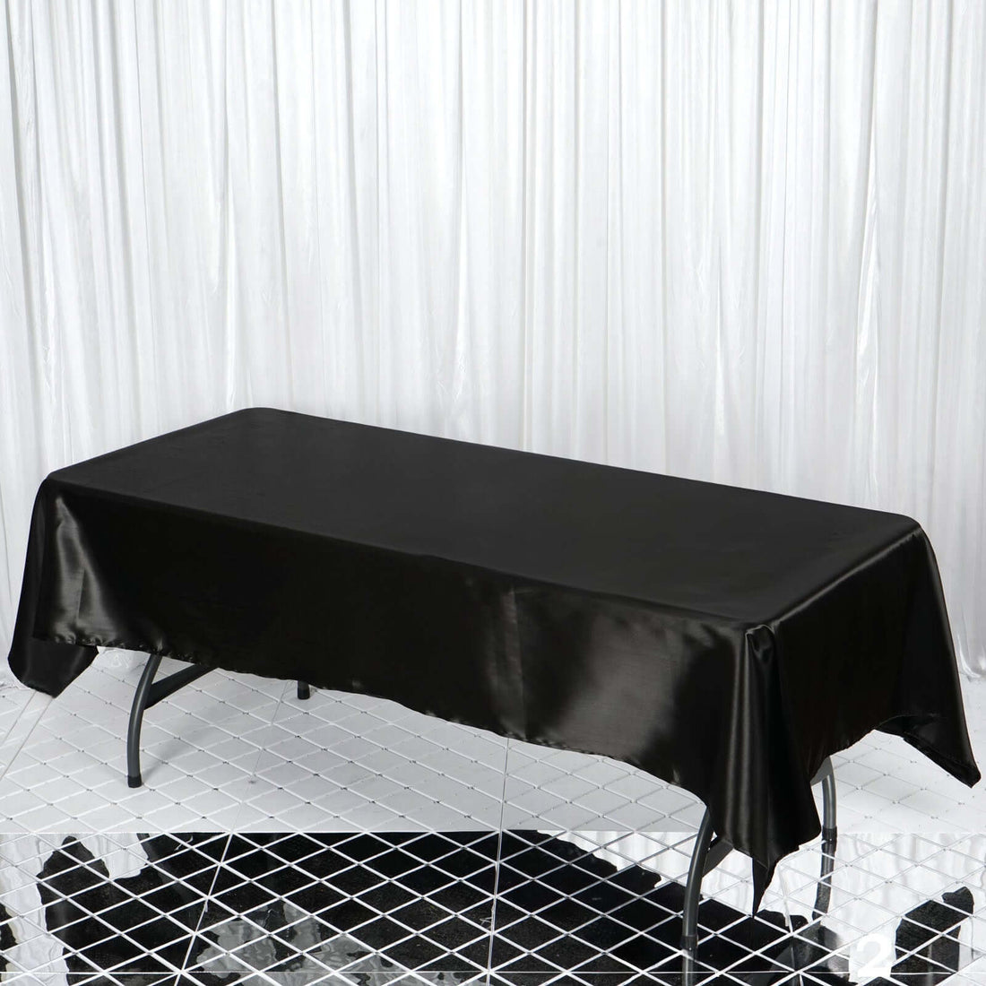 Black satin table cover draped over a rectangular table