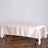 Pink satin tablecloth draped over a table on a plain backdrop