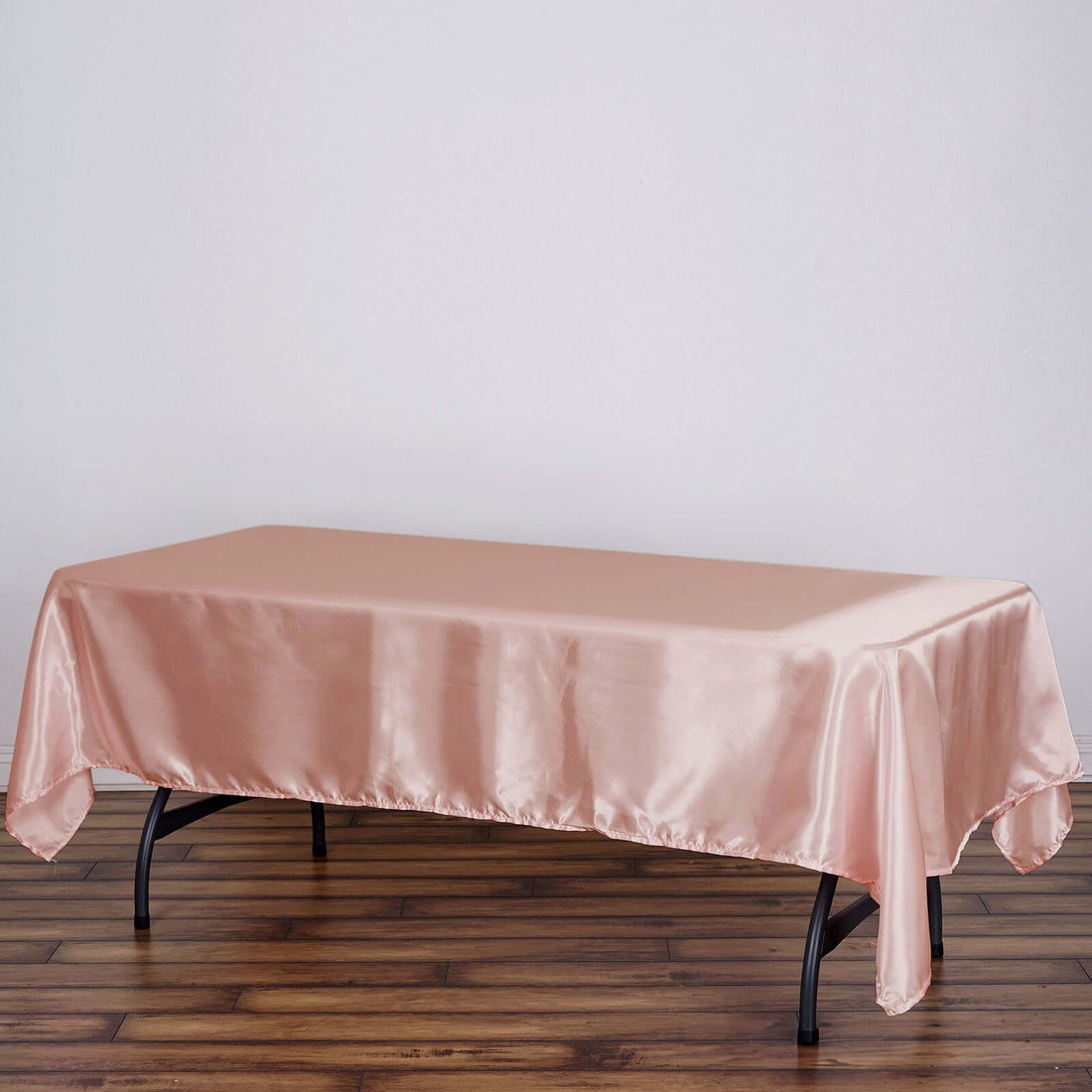 Pink satin tablecloth draped over a rectangular table.