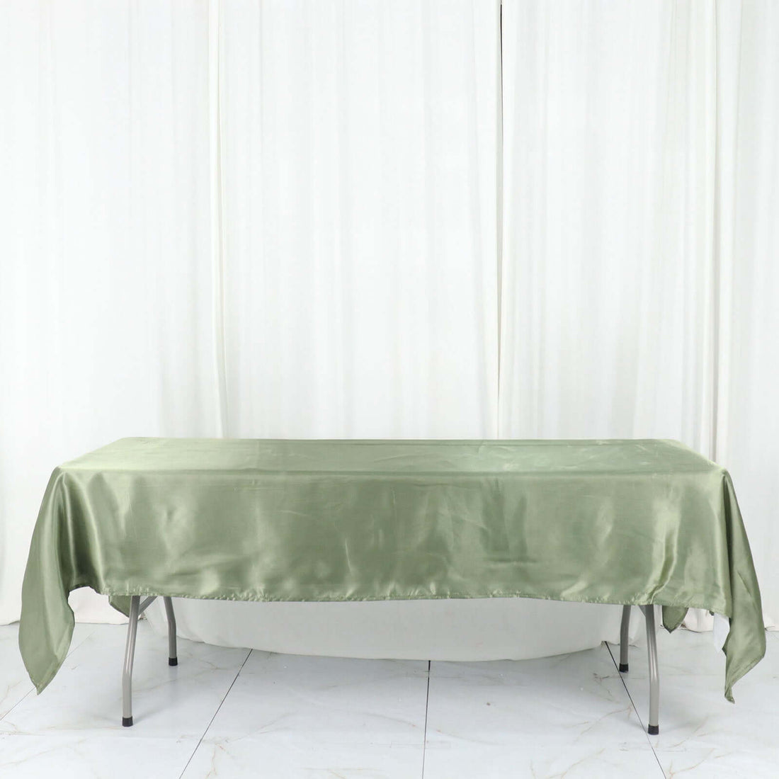 Green satin tablecloth draped over a table.