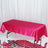Pink satin tablecloth on a table with a reflective surface.