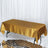 Gold satin tablecloth on a sleek table with a mirrored surface.