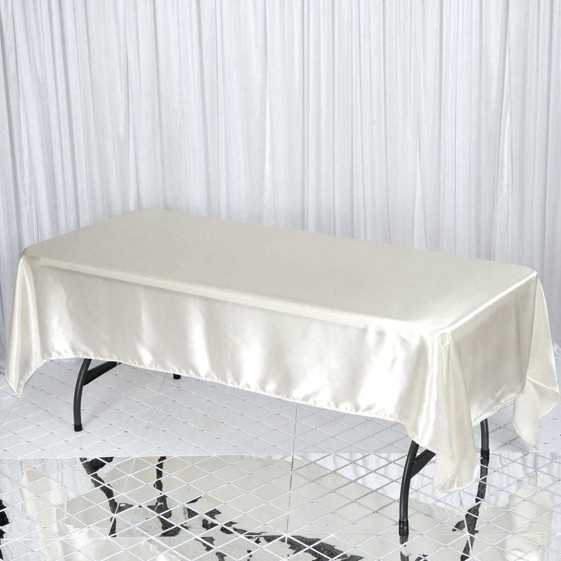 Silk tablecloth draped over a table on a reflective surface