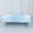 Light blue satin tablecloth draped over a table in a studio setting.