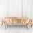 Satin beige tablecloth draped over a table in a studio setting