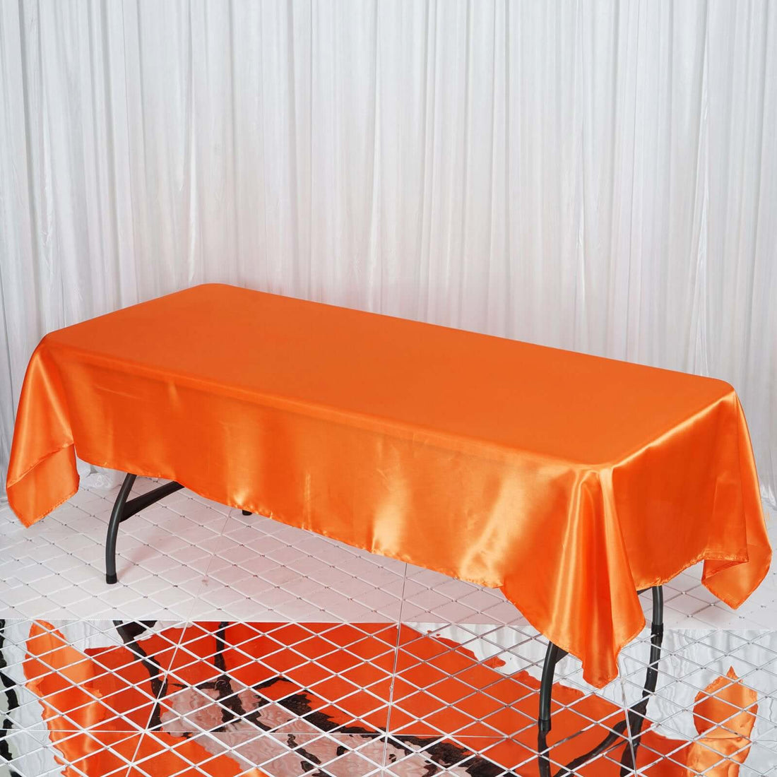 Orange satin tablecloth draped over a rectangular table.