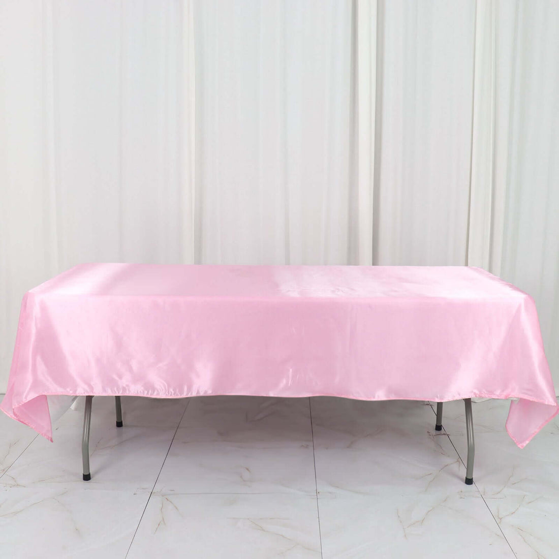 Pink satin tablecloth draped over a folding table