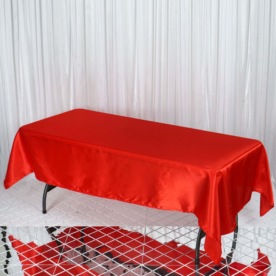 Red satin tablecloth on a table with a textured surface.