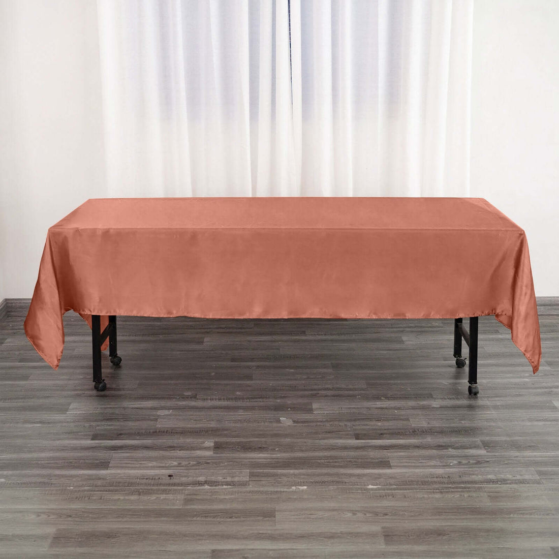 Rust-colored tablecloth draped over a table in a bright room.