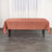 Rust-colored tablecloth draped over a table in a bright room.