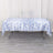Blue floral tablecloth on a table with a white backdrop.