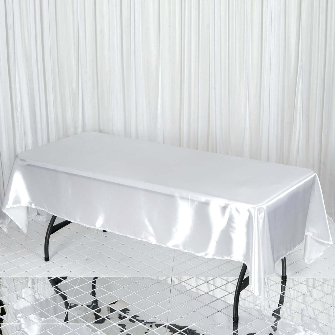 Shiny white tablecloth draped over a rectangular table